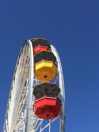 Low angle view of ferris wheel against blue sky