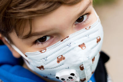 Close-up of boy with protective face mask during covid-19 pandemic.