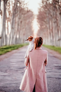 Rear view of woman standing on footpath