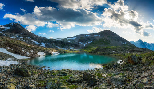 Scenic view of lake by mountains against sky