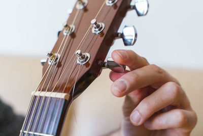 Cropped hand of man holding fretboard