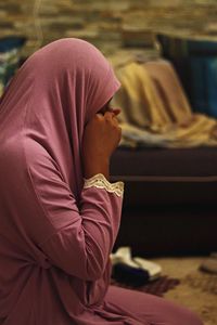 Side view of a woman sitting on floor