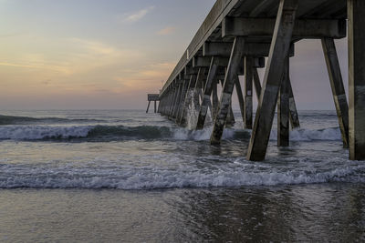 Pier over sea against sky during sunset