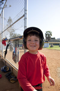 Young boy smiling near the tball dugout