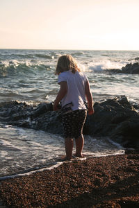 Rear view of woman standing on beach