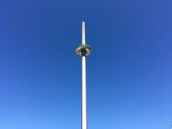 Low angle view of windmill against clear blue sky