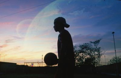 Silhouette man standing against sky during sunset