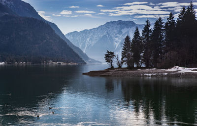 Scenic view of lake by mountains against sky