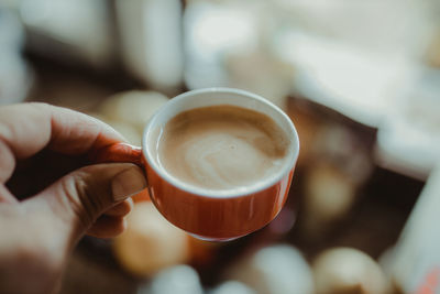 Close-up of hand holding coffee cup