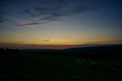 Scenic view of silhouette field against sky during sunset