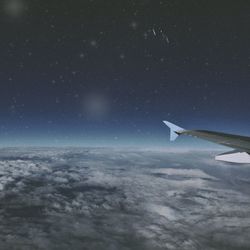 Cropped image of airplane flying over clouds