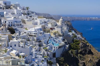 High angle view of cityscape by sea against clear sky