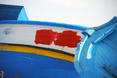 Close-up of multi colored boat against blue sky