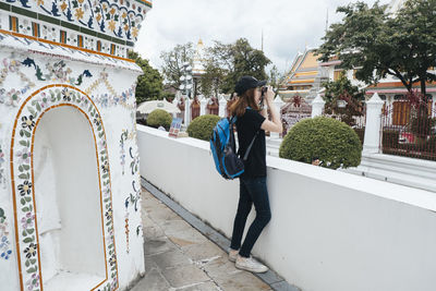 Woman photographing building in city