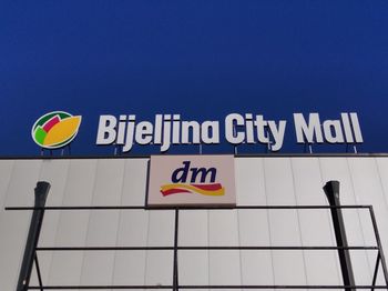 Low angle view of information sign against clear blue sky