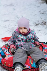 Pensive child sitting on tubing, winter activities for children