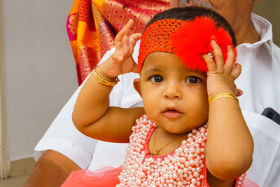 Portrait of cute baby girl sitting on sofa at home