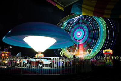 Illuminated ferris wheel against sky at night