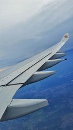 Airplane flying over sea against sky