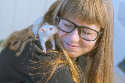 Close-up of smiling girl with rat