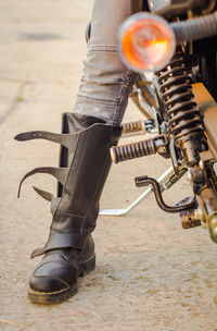 Low section of man with motorcycle on road