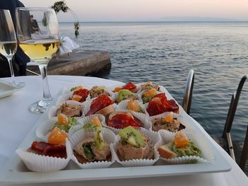 Food on table by sea against sky