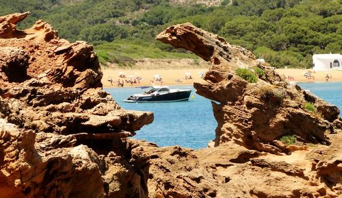 Motorboat in sea seen through rock formation