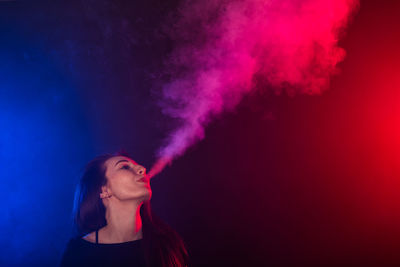 Portrait of beautiful young woman against red wall