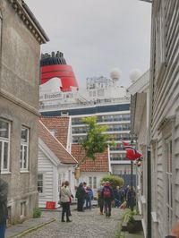 People walking on buildings in city against sky