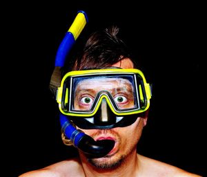 Portrait of man wearing scuba mask against black background