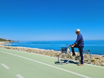 Rear view of man riding bicycle on road