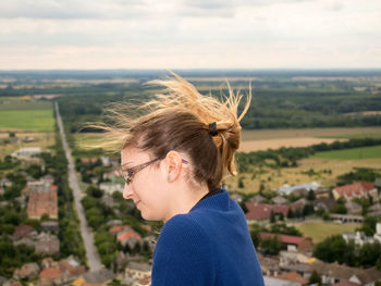 Side view of woman by landscape against sky