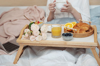 Romantic breakfast with coffee, waffles, orange juice and rose flowers.