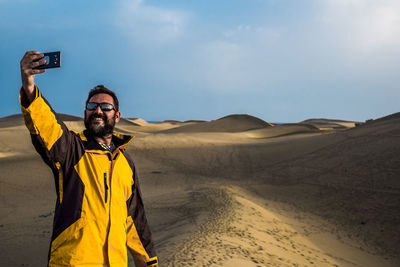 Mature man taking selfie while standing in desert