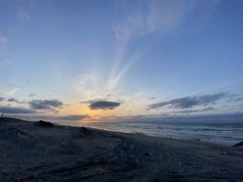 Scenic view of beach against sky during sunset