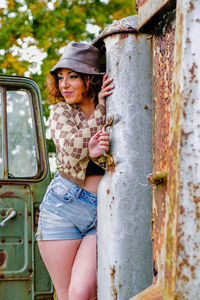 Side view of young woman standing by railing