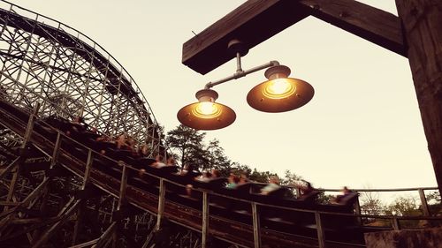 Low angle view of illuminated lanterns hanging against sky