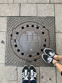 Low section of person standing on tiled floor