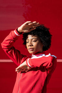 African american woman with short hair and urban dress with red background