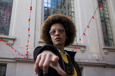 Portrait of woman pointing in city