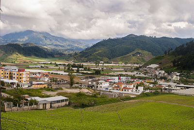 Houses in town against cloudy sky