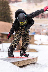 Full length of a boy climbing on snow