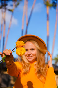 Young woman holding yellow flower
