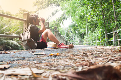 Young man sitting on ground in forest