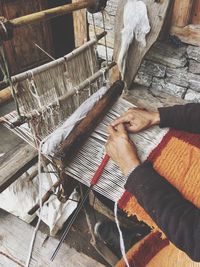 Cropped hands weaving loom in factory