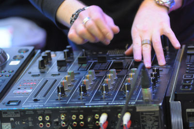 Midsection of man operating sound mixer in club
