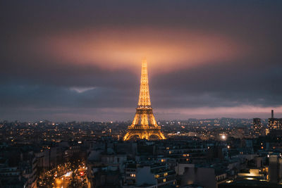 Illuminated buildings in city against sky at night