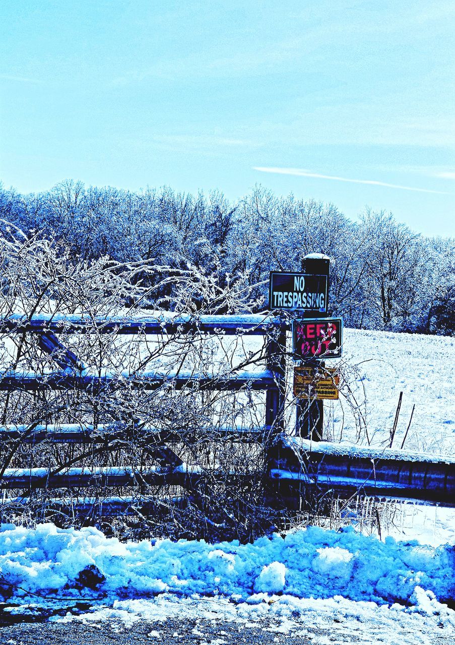 SNOW COVERED FIELD AND TREES AGAINST SKY