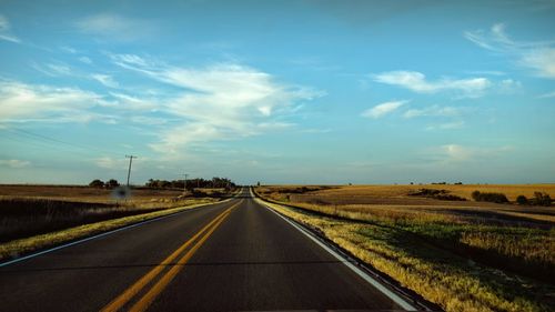 View of country road against cloudy sky