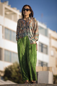 Portrait of woman standing against building